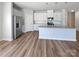 Bright kitchen featuring hardwood floors, white cabinets, stainless steel appliances, and a center island at 2018 Hyacinth Ct, Denver, NC 28037