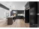Modern kitchen with dark cabinetry, stylish island, and stainless steel appliances, offering sleek design at 212 Sloan St, Belmont, NC 28012