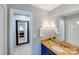 Bathroom with blue vanity, granite countertop, updated fixtures, and decorative mirror at 2324 Chestnut Ln, Matthews, NC 28104