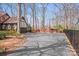 A large driveway leads to a Tudor-style home with a red brick privacy fence on a sunny day at 2324 Chestnut Ln, Matthews, NC 28104