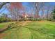 Tudor-style home nestled among mature trees and landscaping, exuding charm and curb appeal at 2324 Chestnut Ln, Matthews, NC 28104