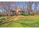A Tudor home boasts a brick facade, dormer windows, and lush landscaping on a sunny day at 2324 Chestnut Ln, Matthews, NC 28104