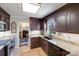 Modern kitchen featuring dark wood cabinetry, granite countertops, stainless appliances, and a view into the dining room at 2324 Chestnut Ln, Matthews, NC 28104