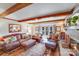 Cozy living room featuring a brick fireplace, exposed wood beams, and comfortable leather seating at 2324 Chestnut Ln, Matthews, NC 28104