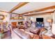 Comfortable living room with exposed beams, brick fireplace, and luxurious leather furniture at 2324 Chestnut Ln, Matthews, NC 28104