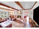 Cozy living room featuring a brick fireplace, exposed beams, and comfortable leather seating for relaxation at 2324 Chestnut Ln, Matthews, NC 28104