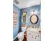 Cozy powder room features blue accent wall, granite countertop, and decorative shelving at 2324 Chestnut Ln, Matthews, NC 28104