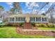 Charming home featuring a symmetrical facade, manicured lawn, and brick accents leading to a bright yellow front door at 3842 Saxonbury Way, Charlotte, NC 28269