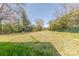 Wide view of a spacious backyard featuring mature trees, a gazebo, and healthy green grass at 410 E Arch St, Lancaster, SC 29720
