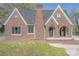 Charming brick home with arched entryway, well-maintained lawn, and classic design at 410 E Arch St, Lancaster, SC 29720