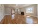 Sunlit living room with polished hardwood floors, featuring a brick fireplace and elegant French doors at 410 E Arch St, Lancaster, SC 29720