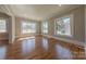 Bright living room featuring hardwood floors, multiple windows offering abundant natural light, and neutral paint at 410 E Arch St, Lancaster, SC 29720