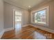 Office with hardwood floors, window, base molding, and access to another room at 410 E Arch St, Lancaster, SC 29720