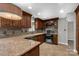 Well-lit kitchen featuring dark cabinets, granite countertops, and stainless steel appliances at 4604 Karwood Dr, Rock Hill, SC 29732