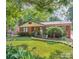Charming brick home featuring mature trees and a lush green lawn at 4824 Harcourt Ln, Charlotte, NC 28212