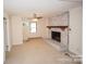Spacious living room with brick fireplace, ceiling fan, and a large window at 4824 Harcourt Ln, Charlotte, NC 28212