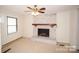 Bright living room with brick fireplace, ceiling fan, and neutral carpet at 4824 Harcourt Ln, Charlotte, NC 28212
