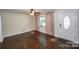 Spacious living room with hardwood floors, large window and a white front door at 4824 Harcourt Ln, Charlotte, NC 28212