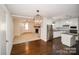 Open-concept living room and kitchen featuring hardwood floors, stainless appliances, and a fireplace at 4824 Harcourt Ln, Charlotte, NC 28212