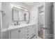 Bathroom featuring dual sinks and vanity and modern fixtures, with view to adjacent bedroom at 5015 Forestmont Dr, Matthews, NC 28105