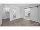 An inviting bedroom with light gray wood-look flooring, neutral walls, and an adjoining bathroom at 5015 Forestmont Dr, Matthews, NC 28105