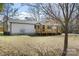 Angle view of house showing wooden front porch and new siding, with a leafless tree in foreground at 5015 Forestmont Dr, Matthews, NC 28105