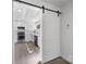 Bright kitchen with stainless steel appliances, white cabinets, and an adjacent sliding barn door at 5015 Forestmont Dr, Matthews, NC 28105