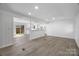 Open-concept living space with stylish gray floors, white walls, and seamless flow to the kitchen at 5015 Forestmont Dr, Matthews, NC 28105