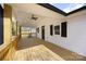 Spacious, covered front porch featuring wood railings and flooring, perfect for relaxing outdoors at 5015 Forestmont Dr, Matthews, NC 28105