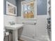 Bathroom featuring pedestal sink, tile walls, grey and white paint, and a window with natural light at 5230 Northview Dr, Hickory, NC 28601