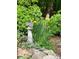 Beautiful garden detail featuring a stone squirrel statue, yellow flowers, and lush green plants at 5230 Northview Dr, Hickory, NC 28601