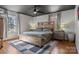 Modern bedroom with wood furnishings, gray and white rug, and dark ceiling fan at 5230 Northview Dr, Hickory, NC 28601