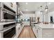 Beautiful kitchen with white cabinets, stainless steel appliances, an island with seating, and gold hardware at 5312 Allburn Pkwy, Concord, NC 28027