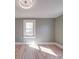 Cozy bedroom featuring refinished hardwood floors, fresh paint, and a large window at 5985 Bertie Ave, Salisbury, NC 28147