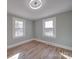 A comfortable bedroom with natural light from two windows and lovely wood flooring at 5985 Bertie Ave, Salisbury, NC 28147