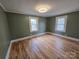 Comfortable bedroom with hardwood floors, neutral paint, and two bright windows at 5985 Bertie Ave, Salisbury, NC 28147