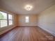 Living room boasts gleaming hardwood floors, large windows for natural light, and neutral paint tones at 5985 Bertie Ave, Salisbury, NC 28147
