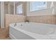 Bathroom featuring soaking tub with tile surround and bright window at 603 Smokehouse Ln, Albemarle, NC 28001
