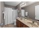 Well-lit bathroom featuring a double vanity, framed mirror, and shower-tub combination with neutral colors at 603 Smokehouse Ln, Albemarle, NC 28001