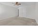 A well-lit bedroom with neutral carpet and a ceiling fan is ready for your personal touches at 603 Smokehouse Ln, Albemarle, NC 28001