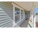 Inviting covered front porch with gray siding and white trim windows, ready for a warm welcome at 603 Smokehouse Ln, Albemarle, NC 28001