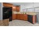 Open kitchen featuring granite countertops, light brown cabinets, stainless steel refrigerator and black dishwasher at 603 Smokehouse Ln, Albemarle, NC 28001
