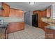 Well-lit kitchen featuring dark wood cabinets, granite countertops, and modern appliances against neutral-toned walls at 603 Smokehouse Ln, Albemarle, NC 28001