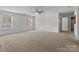 Large living room with neutral carpet, updated ceiling fan, decorative molding and lots of windows at 603 Smokehouse Ln, Albemarle, NC 28001