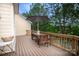 Large back deck featuring wooded views with a wooden table set and neutral umbrella at 609 Sunfish Ln, Tega Cay, SC 29708