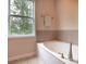 Relaxing bathroom showcasing a luxurious soaking tub beneath a bright window at 609 Sunfish Ln, Tega Cay, SC 29708