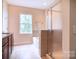 Bright bathroom featuring a soaking tub, glass-enclosed shower, and warm-toned tile at 609 Sunfish Ln, Tega Cay, SC 29708
