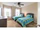 Bright bedroom with two twin beds, each adorned with colorful floral bedding, and a ceiling fan at 609 Sunfish Ln, Tega Cay, SC 29708