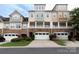 Charming townhome showcasing a stone facade, a row of garages, and manicured landscaping at 609 Sunfish Ln, Tega Cay, SC 29708