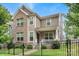Charming two-story home featuring brick and siding accents, a small front porch and black metal fence at 619 R L Stowe Rd, Belmont, NC 28012